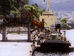 石山から基礎石をダンプトラックで運搬し、平田基地で船に積み込みます。