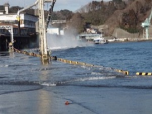 地盤沈下により高潮で岸壁を越波する様子